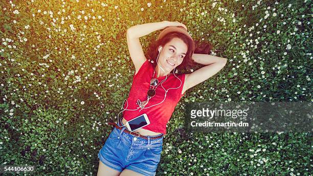 hippie girl lying down in the grass - girl lying down stock pictures, royalty-free photos & images