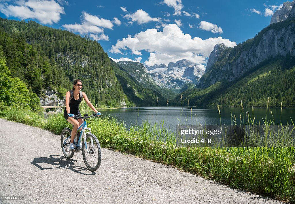 Woman on E-Bike Mountainbike in Nature, Lake Gosau, Dachstein Glacier