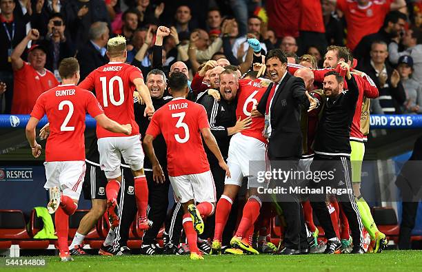 Chris Coleman manager of Wales celebrates Ashley Williams of after scoring his team's first goal during the UEFA EURO 2016 quarter final match...