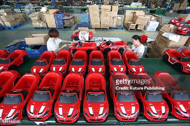 Staff work with toy cars in a toy factory on July 01, 2016 in Jinjiang, China. PHOTOGRAPH BY Feature China /