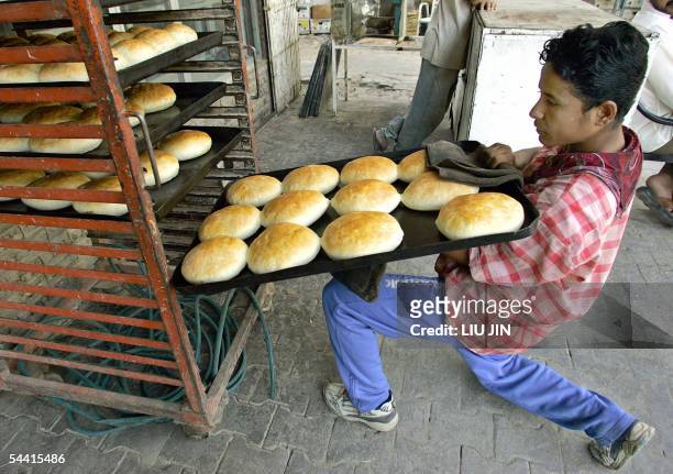 An Iraqi worker places fresh breads on a shelf at a bakery in Baghdad, 03 September 2005. Iraq's Prime Minister Ibrahim Jaafari said that Sunni and...