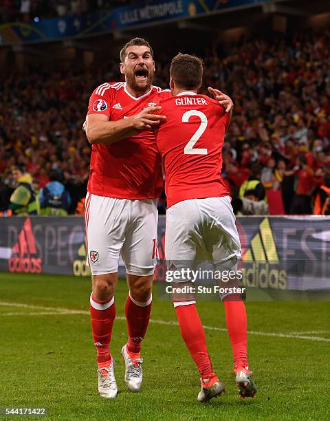Sam Vokes of Wales celebrates scoring his team's third goal with his team mates Chris Gunter during the UEFA EURO 2016 quarter final match between...