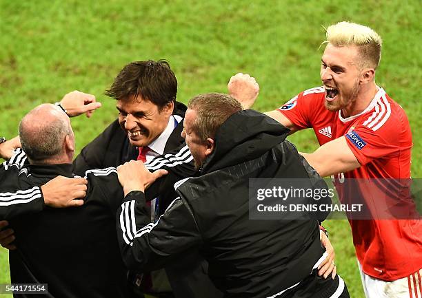 Wales' midfielder Aaron Ramsey celebrates with Wales' coach Chris Coleman and team staff at the end of the Euro 2016 quarter-final football match...