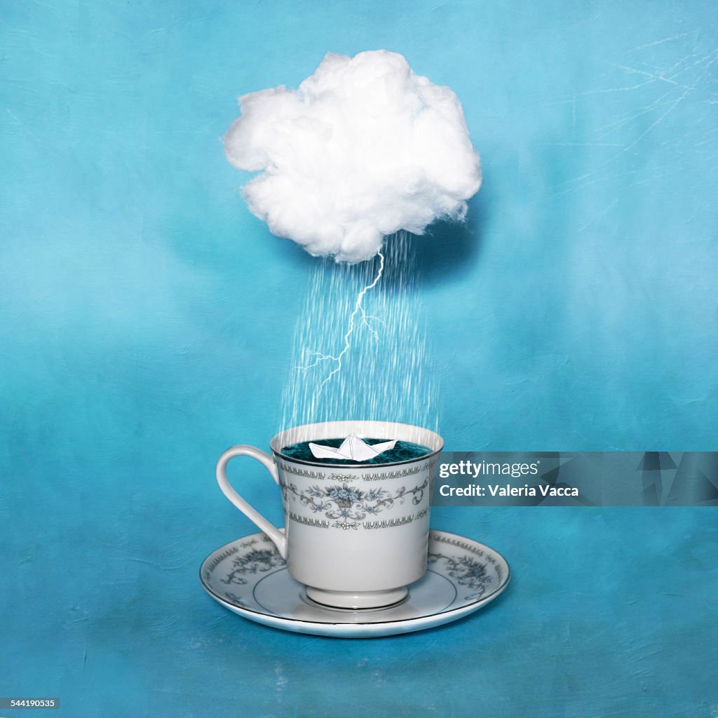 Paper boat in a teacup during a thunderstorm