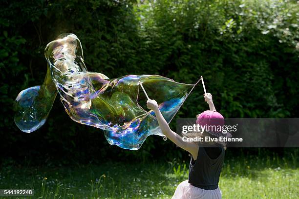 child playing with large bubbles - big bubble foto e immagini stock