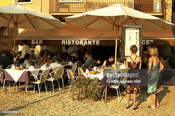 Italien, Gardasee, Restaurant "La Pace" in Malcesine. Zwei Touristinnen schauen auf die Speisekarte