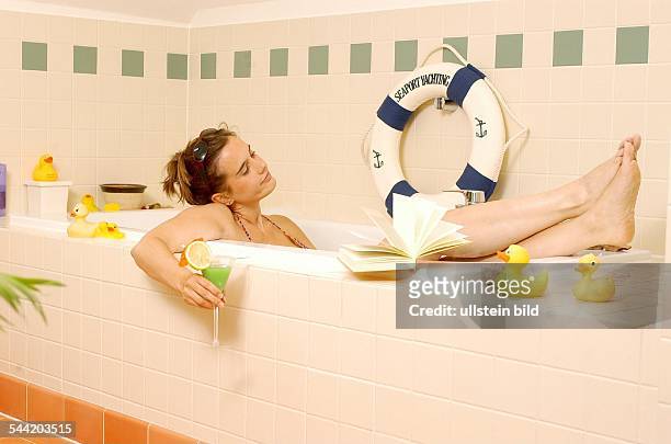 Deutschland, - Junge Frau entspannt sich in der Badewanne mit einem Buch und einem Cocktail- -vorhanden