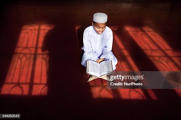 Madrasa student is reading the holy Quran in a madrasa in Dhaka; Bangladesh, July 1st, 2016