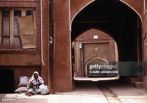 Iran, Abyaneh: Frau vor ihrem aus Lehm gebauten Haus. Das Gebirgsdorf Abyaneh ist wegen seiner traditionellen Lehmziegelarchitektur beruehmt. Seine...