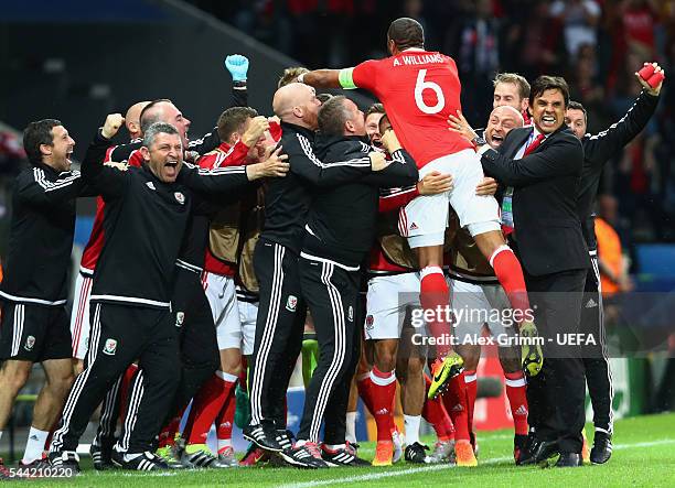Ashley Williams of Wales dives to his team mates and staffs to celebrate scoring his team's first goal during the UEFA EURO 2016 quarter final match...