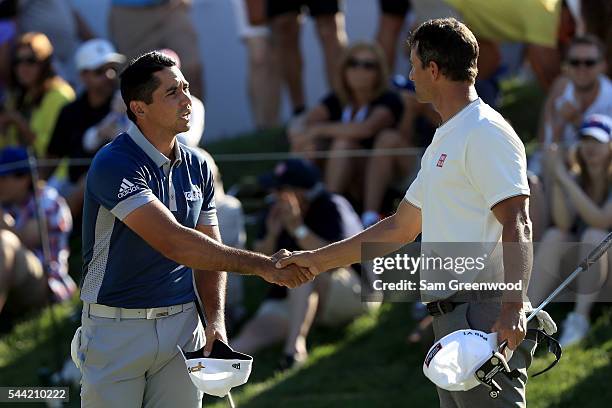 Jason Day of Australia and Adam Scott of Australia shake hands at the end of their round on the 18th green during the second round of the World Golf...