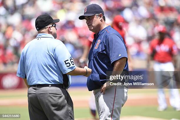 Manager John Farrell of the Boston Red Sox argues a call at first base with umpire Eric Cooper during the game against the Texas Rangers at Globe...