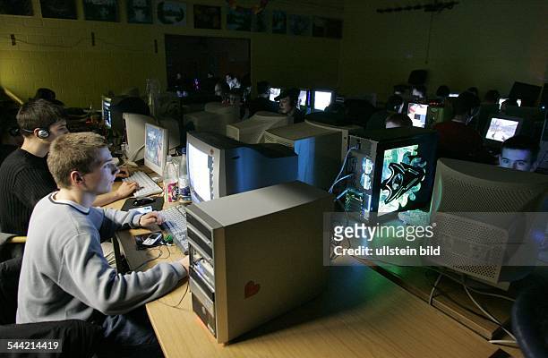 Jugendliche bei einer LAN Party mit Computerspielen. Duch Vernetzung der Computer koennen mehrere Spieler gegeneinander spielen