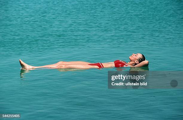 Israel, , Totes Meer - Schwimmeen im toten Meer, Schwimmerin in rotem Bikini liegt an der Wasseroberfläche