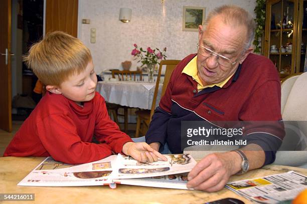 Großvater und Enkel schauen sich ein Bilderbuch an