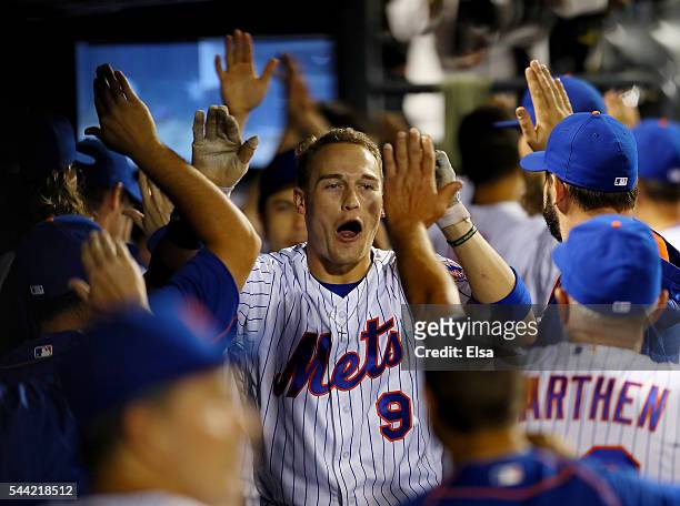 Brandon Nimmo of the New York Mets is congratulated by teammates in the dugout after he hit his first major league home run in the fourth inning...