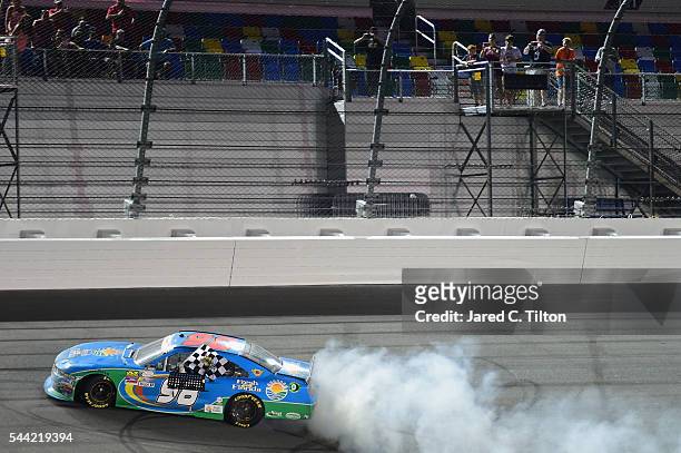 Aric Almirola, driver of the Fresh From Florida Ford, celebrates with a burnout after winning the NASCAR XFINITY Series Subway Firecracker 250 at...