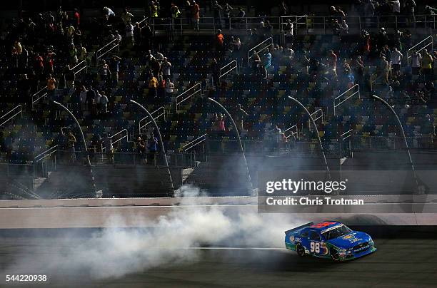 Aric Almirola, driver of the Fresh From Florida Ford, celebrates with a burnout after winning the NASCAR XFINITY Series Subway Firecracker 250 at...