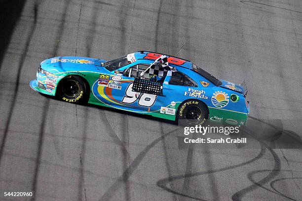 Aric Almirola, driver of the Fresh From Florida Ford, celebrates with the checkered flag after winning the NASCAR XFINITY Series Subway Firecracker...