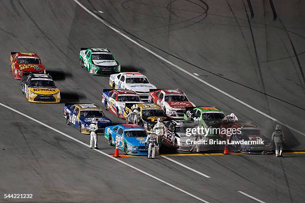 Officials stop the cars on pit road after a caution was thrown in overtime during the NASCAR XFINITY Series Subway Firecracker 250 at Daytona...