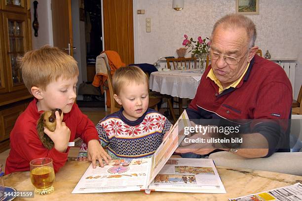 Großvater und Enkel schauen sich ein Bilderbuch an