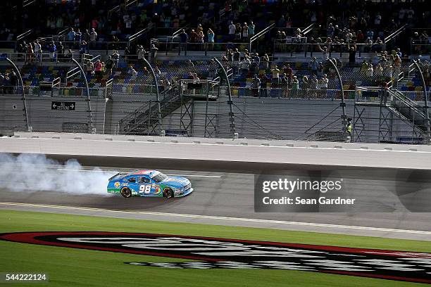 Aric Almirola, driver of the Fresh From Florida Ford, celebrates with a burnout after winning the NASCAR XFINITY Series Subway Firecracker 250 at...