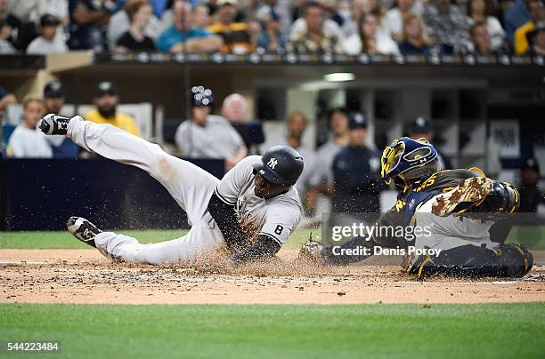 Didi Gregorius of the New York Yankees scores ahead of the tag of Derek Norris of the San Diego Padres during the second inning of a baseball game at...