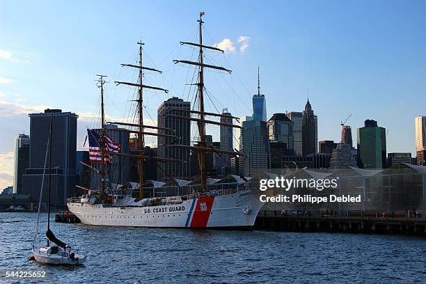 usa, new york city, brooklyn, the u.s coast guard cutter eagle at pier 5 of brooklyn bridge park and lower manhattan at the background - coast guard stock pictures, royalty-free photos & images