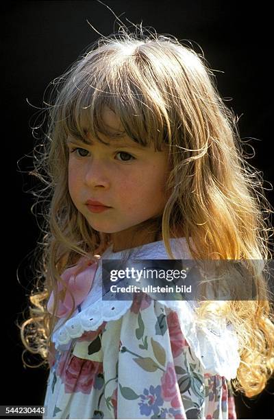 Deutschland, Portraet: Vierjaehriges Maedchen mit langem blonden Haar und Rueschenkleid.