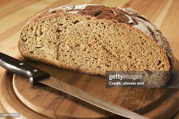 Landbrot und Brotmesser auf einem Holzbrett- 2005