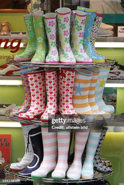 Bunte Gummistiefel auf einem Staender in einem Schuhgeschaeft