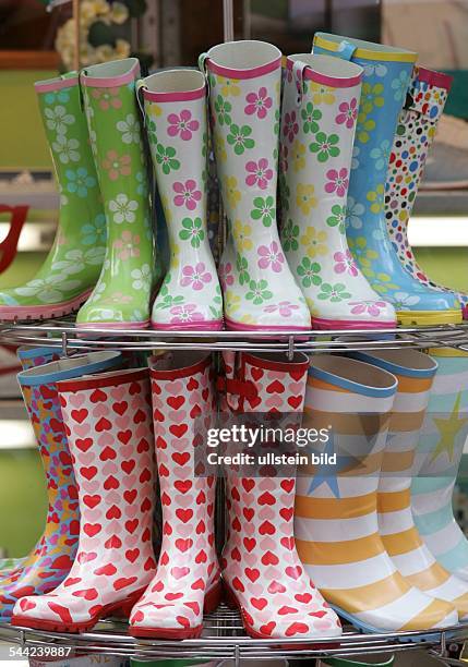 Bunte Gummistiefel auf einem Staender in einem Schuhgeschaeft