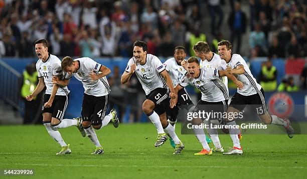 Germany players dash to celebrate their win through the penalty shootout after Jonas Hector scores to win the game after the UEFA EURO 2016 quarter...