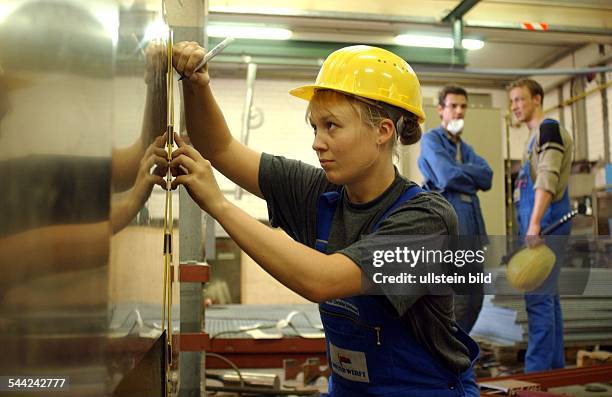 Deutschland, Niedersachsen, Papenburg - Ausbildung in der Metallindustrie. Hier im Schiffbau auf der Meyerwerft iweibliche Auszubildende an einem...