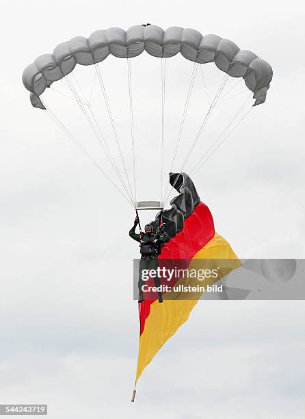 Deutschland, Nordrhein-Westfalen, Sankt Augustin - BGS-Fallschirmspringer mit einer Deutschlandfahne beim Absprung