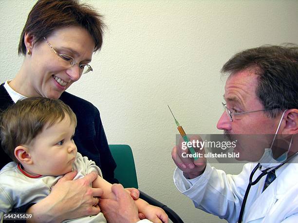 Kleiner Junge mit seiner Mutter beim Kinderarzt erhaelt eine Spritze