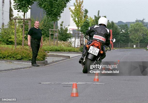 Fahrlehrer und Fahrschueler bei einer Fahrstunde in der Fahrschule für Motorradfahrer