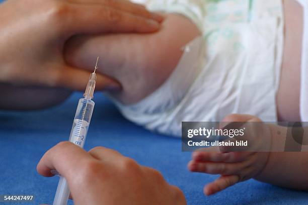 Baby beim Kinderarzt: Kind bekommt eine Spritze in den Oberschenkel des Kindes