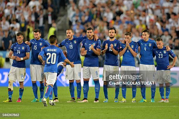 Italy players congratulate Italy's forward Lorenzo Insigne after he scored a goal in the penalty shoot-out in the Euro 2016 quarter-final football...