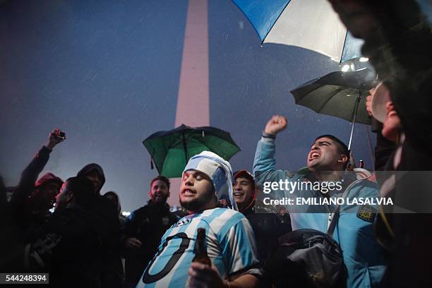 Fans of Argentine football star Lionel Messi rally under the rain asking for his return to the national team at the Obelisco in Buenos Aires on July...