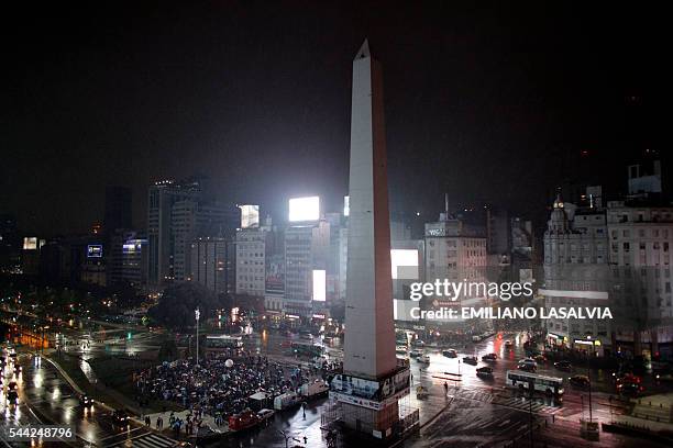 Fans of Argentine football star Lionel Messi rally under the rain asking for his return to the national team at the Obelisco in Buenos Aires on July...