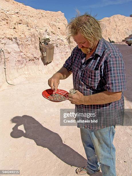 Australien, South Australia, Coober Pedy - Schatzsucher und Bergbauer Don praesentiert Opale aus der hauseigenen Mine, Crocodile`s Nest