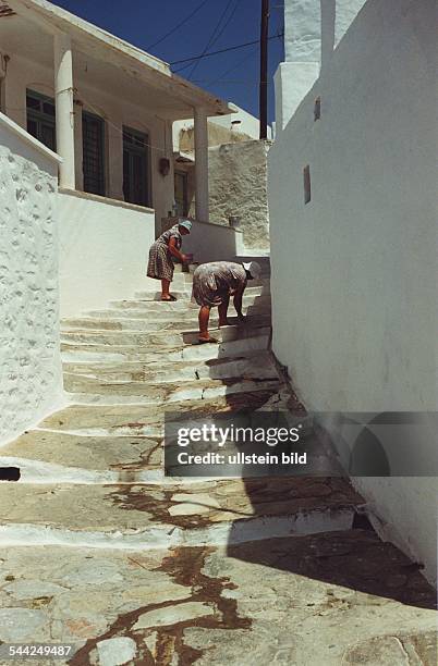 Griechenland, Griechische Inseln, Kykladen, Insel Sifnos, Artemonas, Frauen streichen die Treppen weiss an