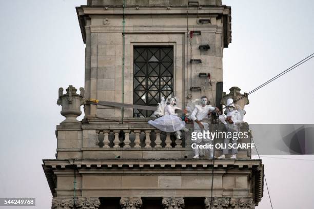 Performers attached to high-wires prepare for lift-off during the outdoor aerial performance of the show "Place des Anges" , performed by French...