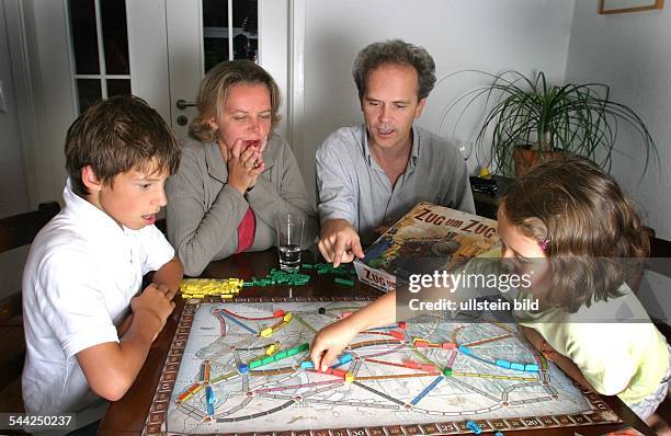 Familie spielt das Gesellschaftsspiel "Zug um Zug" - 2004