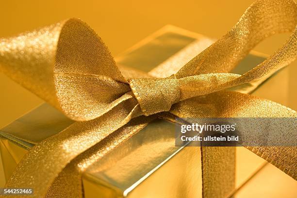 Geschenk in Goldpapier eingewickelt mit goldener Schleife