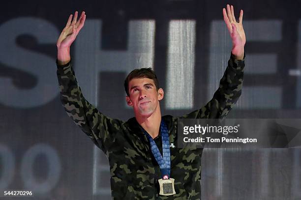 Michael Phelps of the United States participates in the medal ceremony for the Men's 100 Meter Butterfly during Day Seven of the 2016 U.S. Olympic...