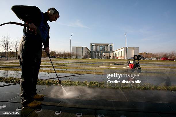 Deutschland, Berlin - Mitte, Reinigungsarbeiten mit Hochdruckreiniger. Im Hintergrund das Bundeskanzleramt