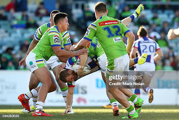 Nathan Ross of the Knights is up ended in a tackle during the round 17 NRL match between the Canberra Raiders and the Newcastle Knights at GIO...