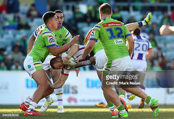 Nathan Ross of the Knights is up ended in a tackle during the round 17 NRL match between the Canberra Raiders and the Newcastle Knights at GIO...